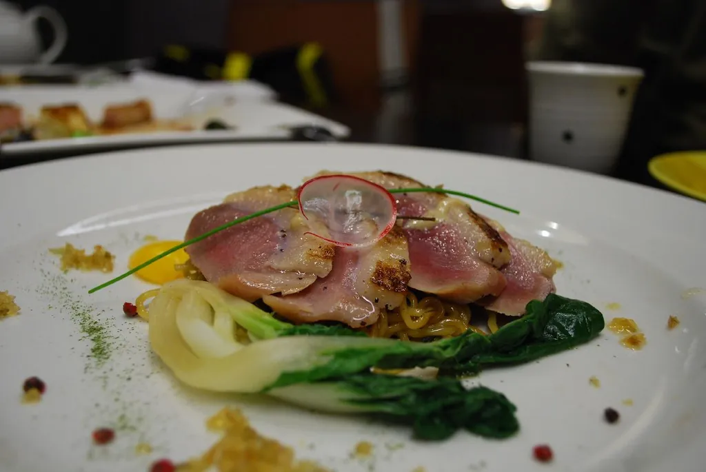 Atún braseado con pak choi en plato blanco