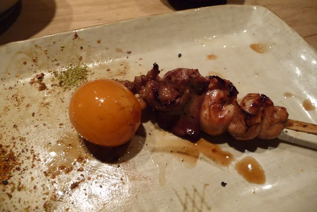 Yakitori de muslo de pollo de corral con yema curada en soja.